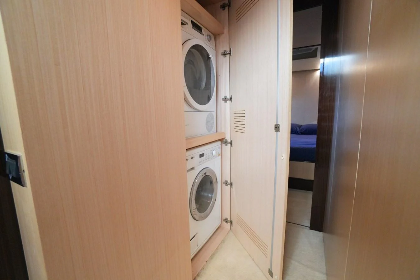 The yacht features a convenient laundry area with stacked washer and dryer units. aboard HUBO Yacht for Sale