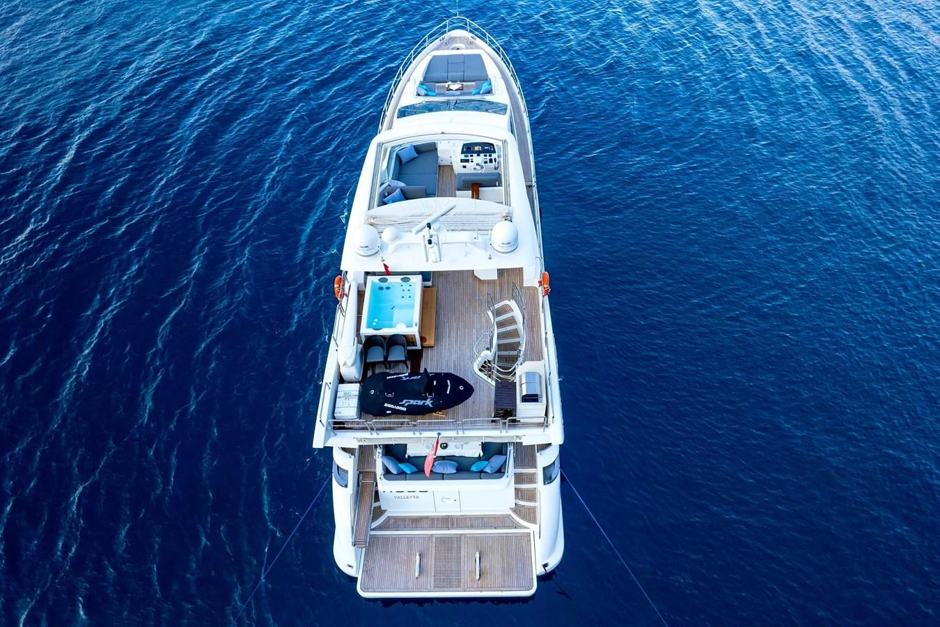 This aerial view showcases the aft deck of a luxurious yacht, highlighting its spacious layout and inviting amenities. aboard HUBO Yacht for Sale