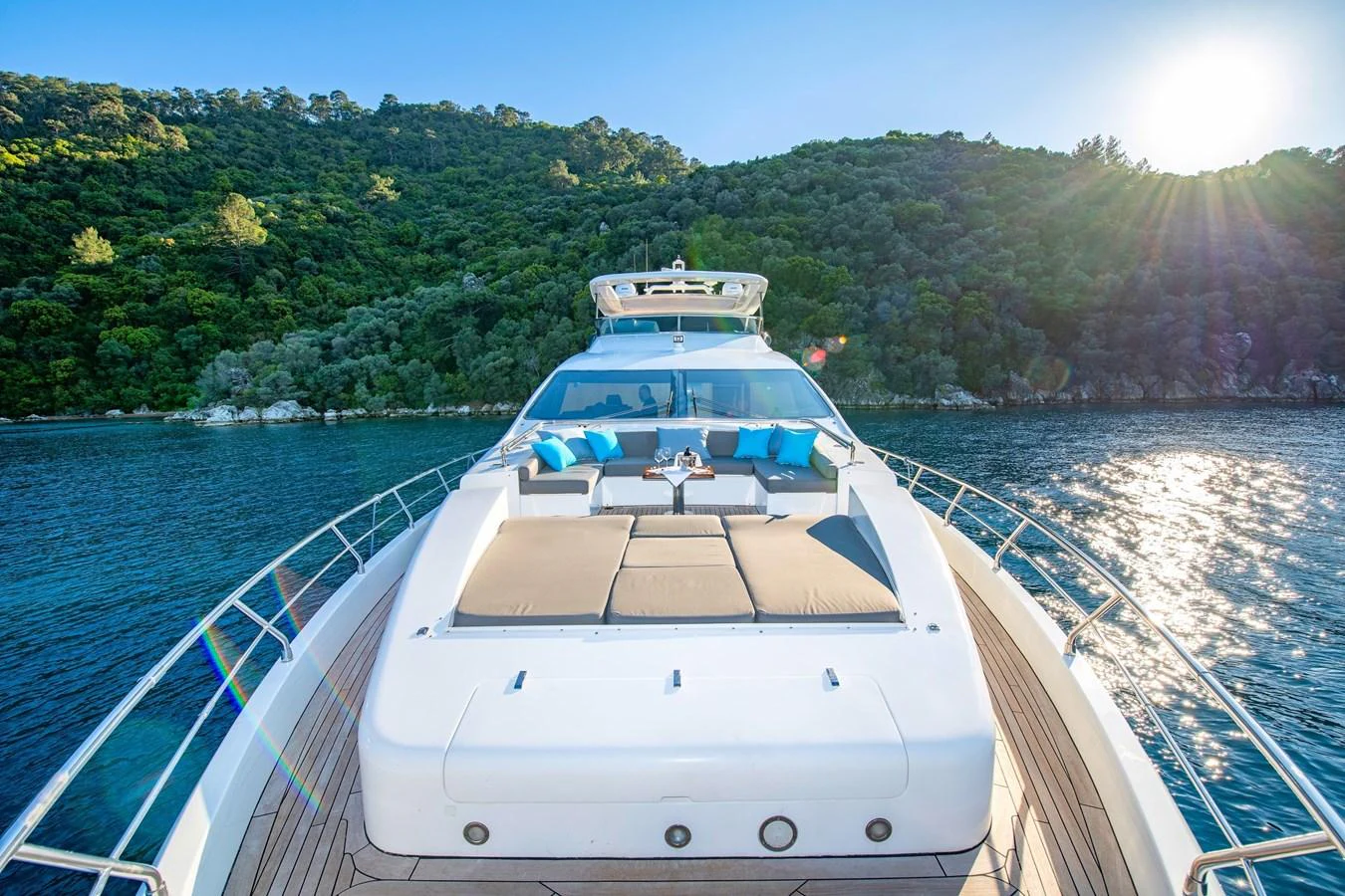 The yacht's foredeck features a spacious sunbathing area with plush cushions and stunning views. aboard HUBO Yacht for Sale