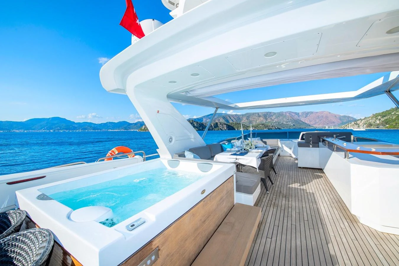 The sundeck features a luxurious hot tub and ample seating with stunning views of the surrounding waters. aboard HUBO Yacht for Sale