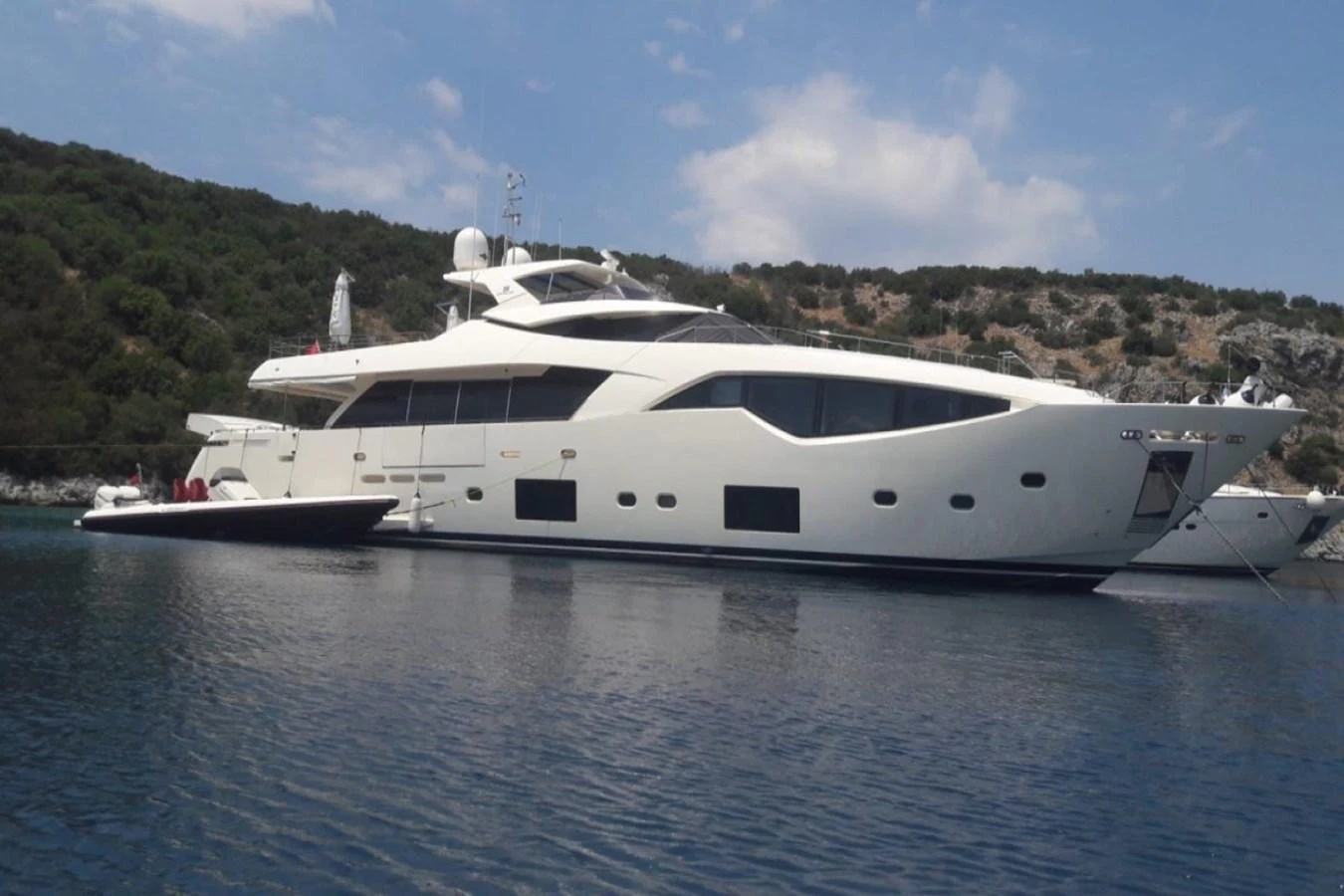 A sleek and modern yacht is anchored in a serene bay, showcasing its elegant design and luxurious features. aboard HAPPY 2 Yacht for Sale