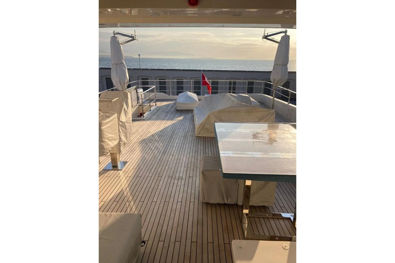 The sundeck offers a spacious area with covered furniture and a serene view of the sea. aboard HAPPY 2 Yacht for Sale