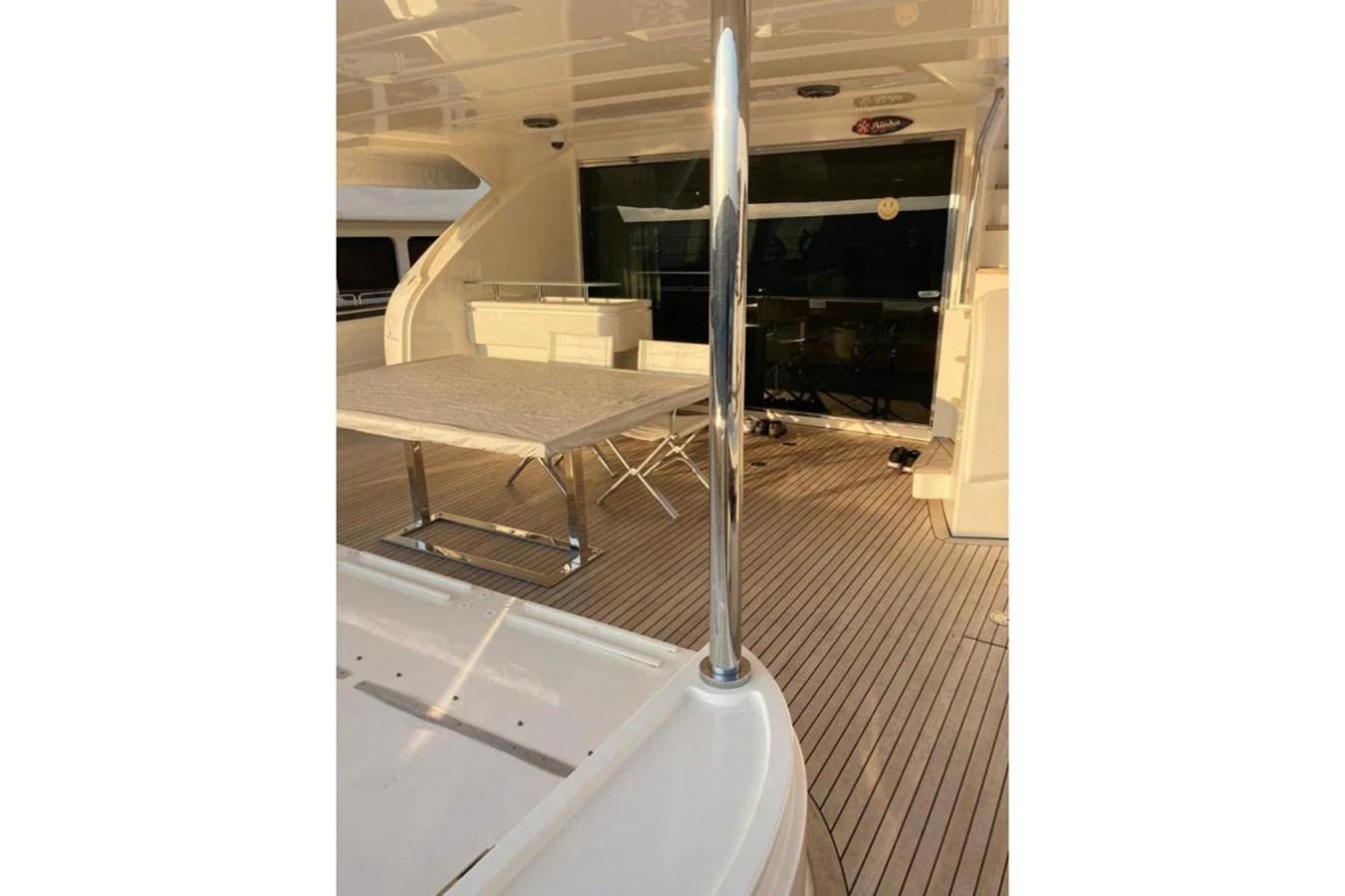 The aft deck features a spacious seating area with a table, perfect for outdoor dining and relaxation. aboard HAPPY 2 Yacht for Sale