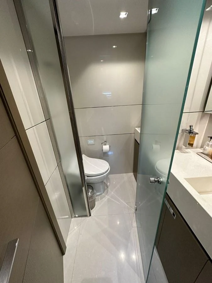 A sleek and modern yacht bathroom with a glass shower door and contemporary fixtures. aboard HAPPY 2 Yacht for Sale