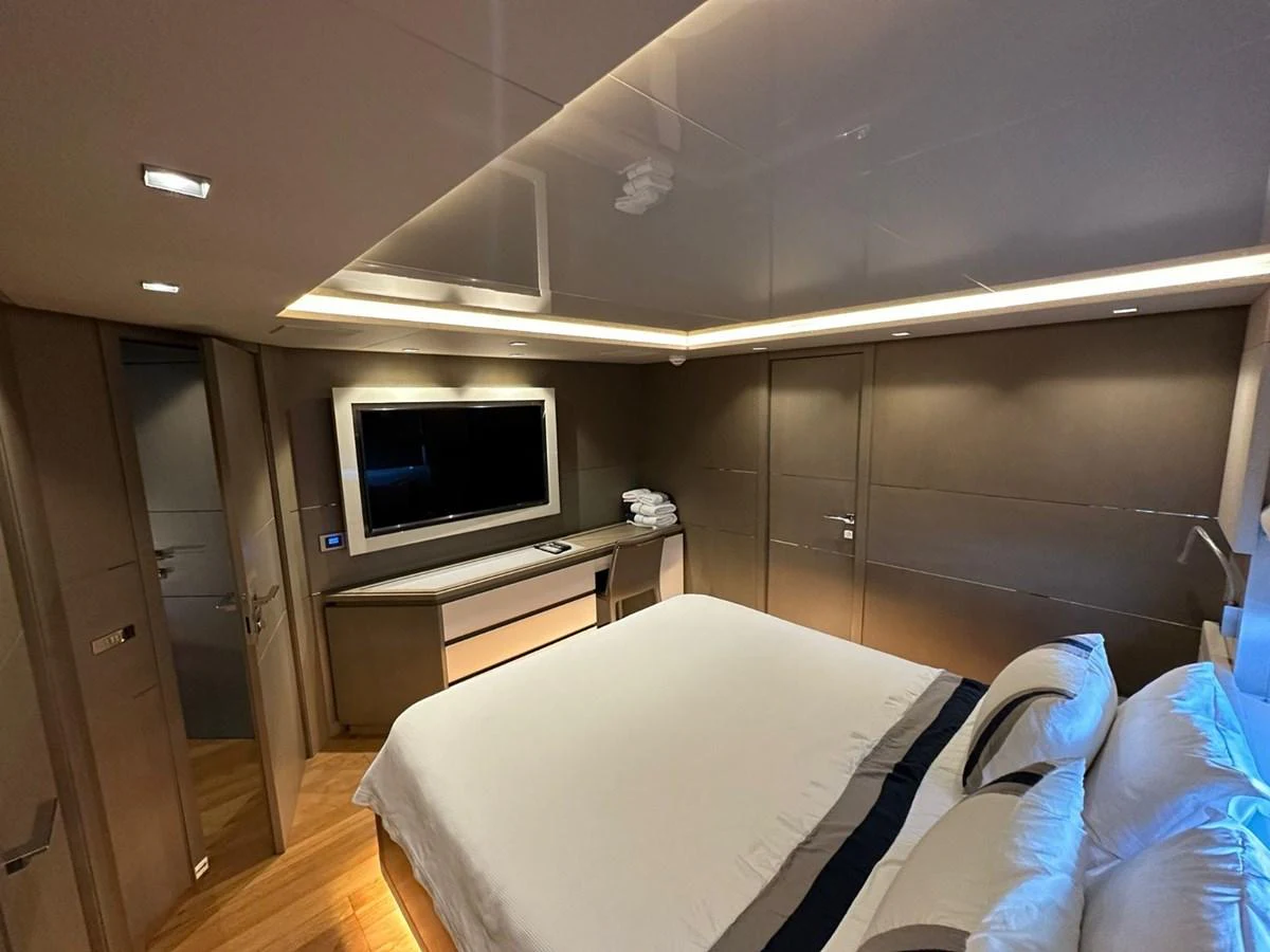 The stateroom features a luxurious bed, modern lighting, and a flat-screen TV for ultimate relaxation. aboard HAPPY 2 Yacht for Sale