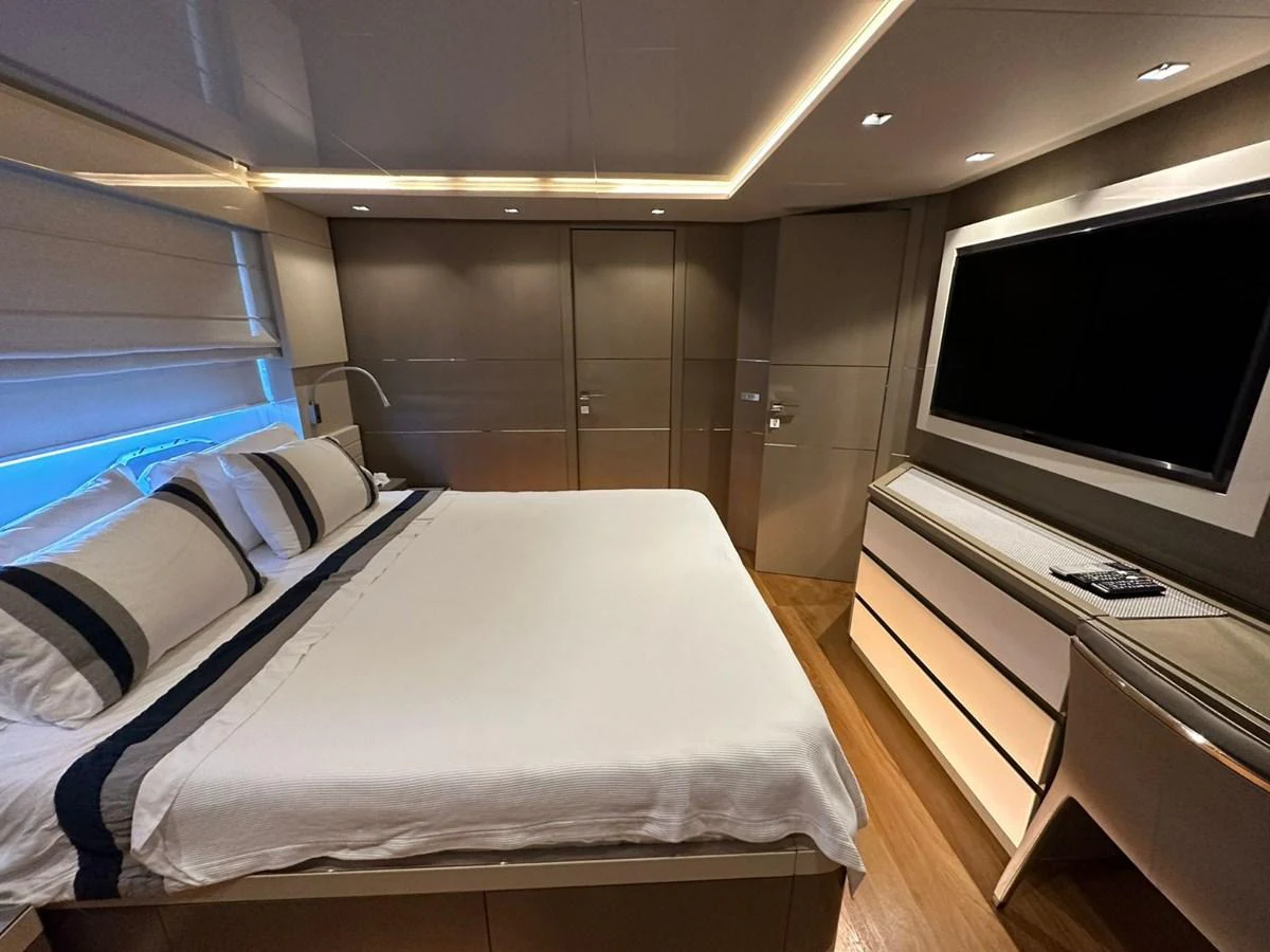 The stateroom features a luxurious bed with elegant bedding and a large flat-screen TV. aboard HAPPY 2 Yacht for Sale
