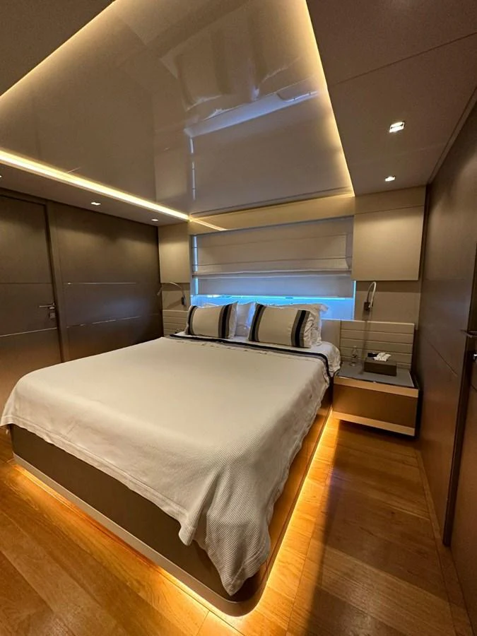 A luxurious stateroom featuring a cozy bed with ambient lighting and modern decor. aboard HAPPY 2 Yacht for Sale