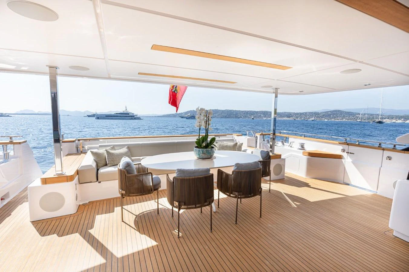 a table and chairs on a deck overlooking a body of water aboard HAIAMI I Yacht for Sale