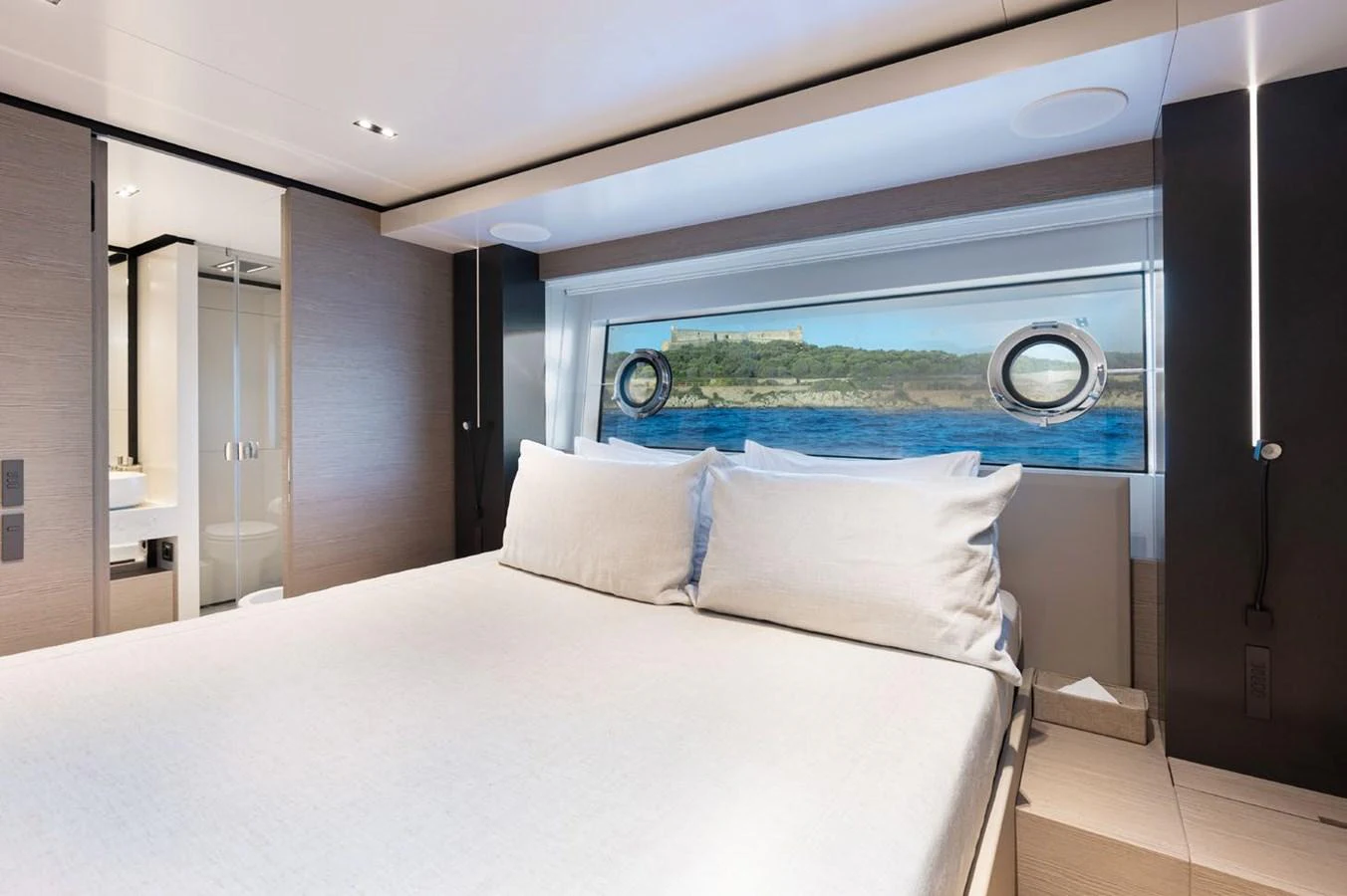 a bed with a large window aboard HAIAMI I Yacht for Sale