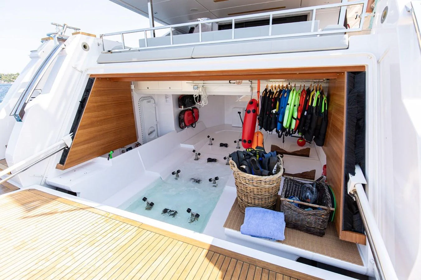 a small kitchen with a sink and a rack of clothes aboard HAIAMI I Yacht for Sale