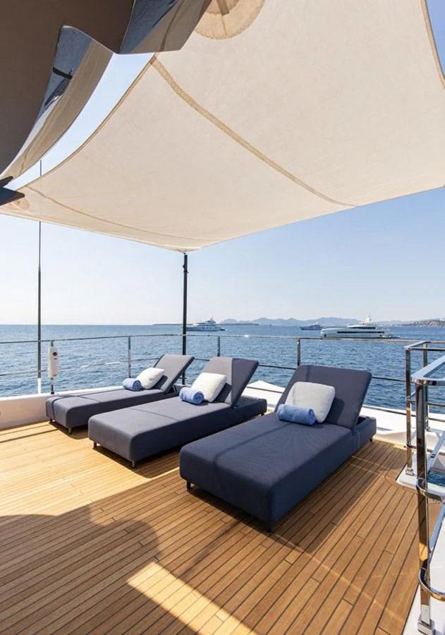 a large lounge area with a large umbrella over it aboard HAIAMI I Yacht for Sale