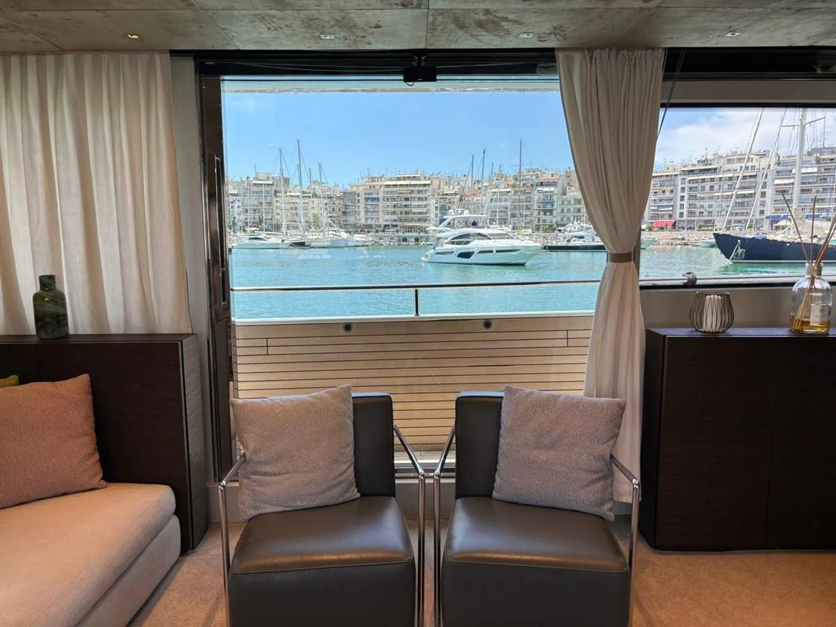 The yacht's interior offers a cozy seating area with a stunning view of the marina through large windows. aboard SANLORENZO Yacht for Sale