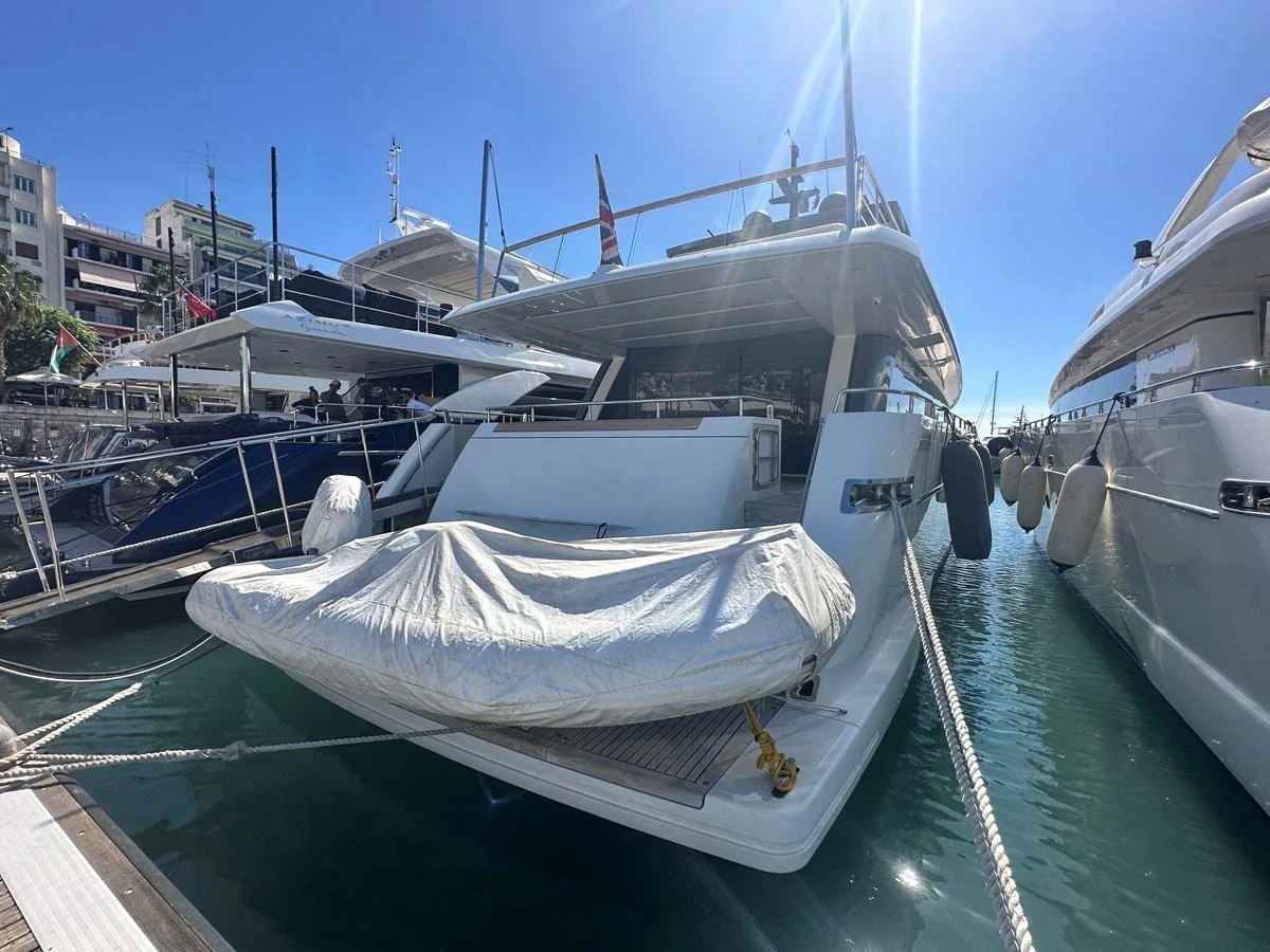 The yacht is docked at the marina, showcasing its spacious aft deck with a covered tender. aboard SANLORENZO Yacht for Sale