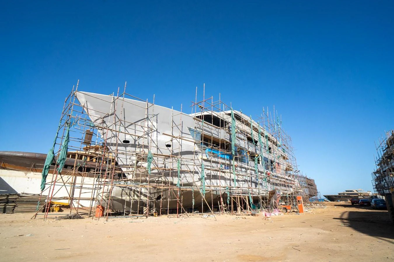 The yacht is under construction, surrounded by scaffolding on a clear day. aboard JASMINE Yacht for Sale