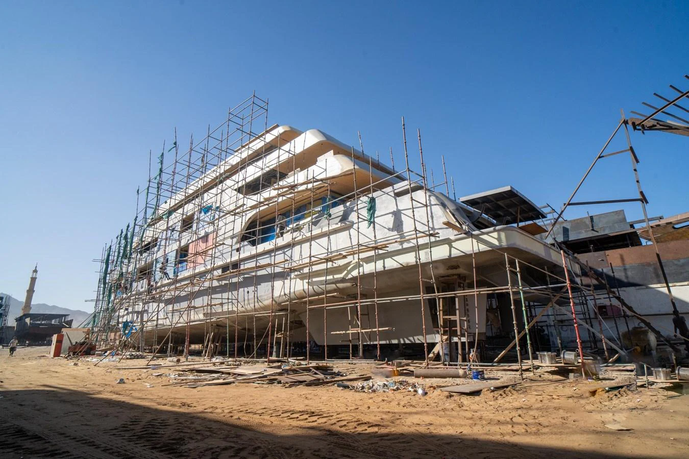 A yacht under construction, surrounded by scaffolding and building materials. aboard JASMINE Yacht for Sale