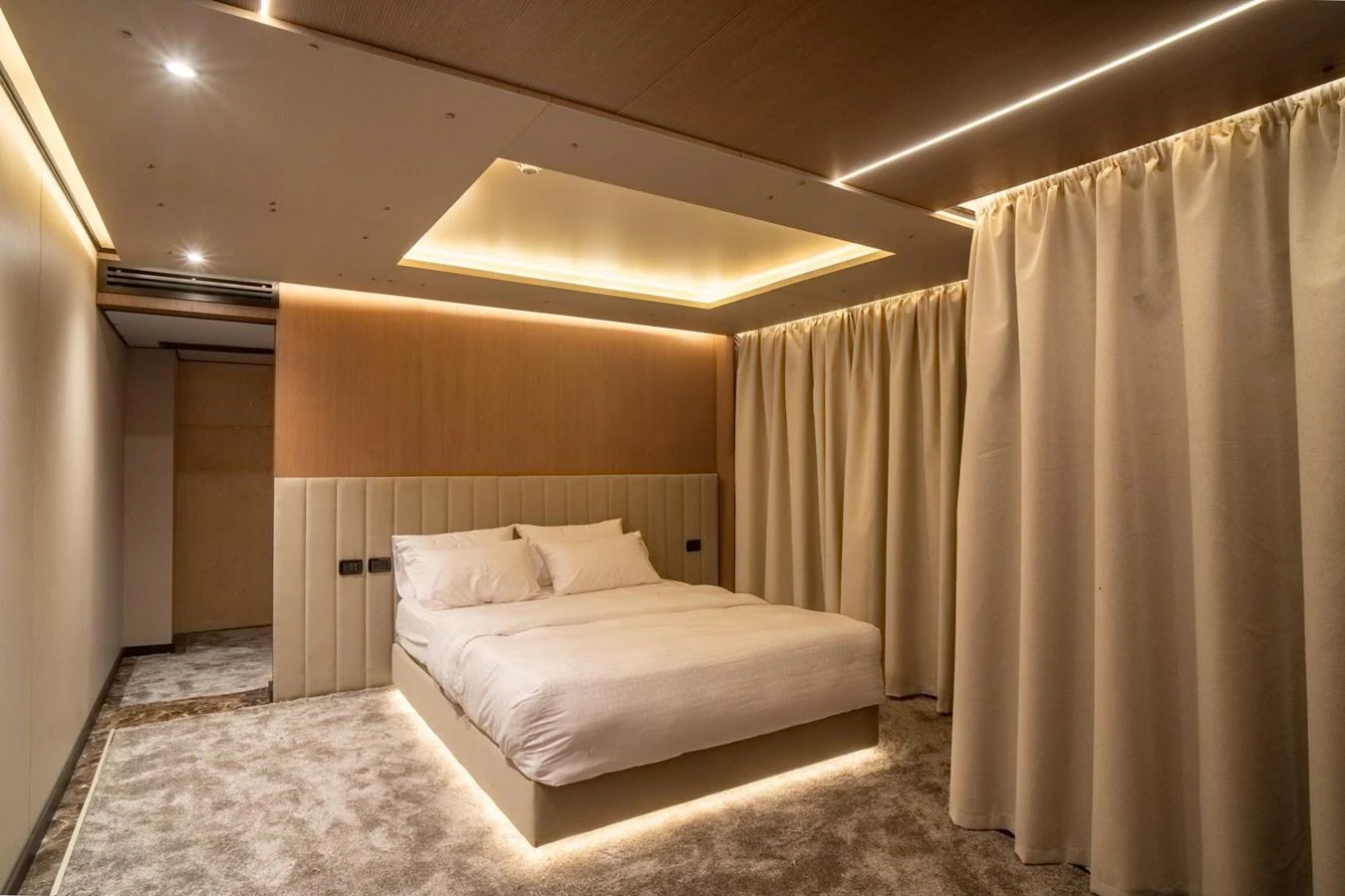 The stateroom features a luxurious bed with ambient lighting and elegant curtains for a serene atmosphere. aboard JASMINE Yacht for Sale