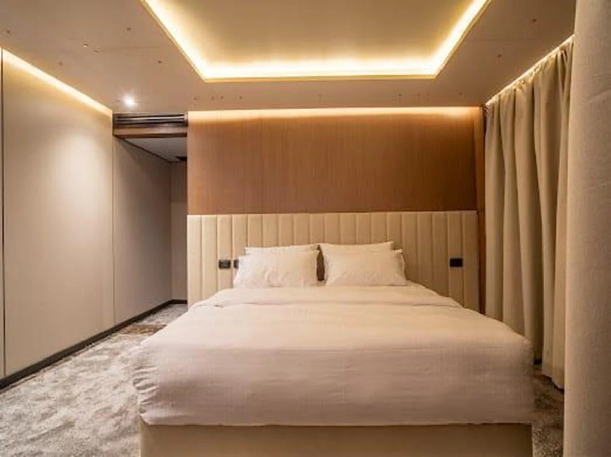 The stateroom features a luxurious bed with elegant lighting and modern decor. aboard JASMINE Yacht for Sale