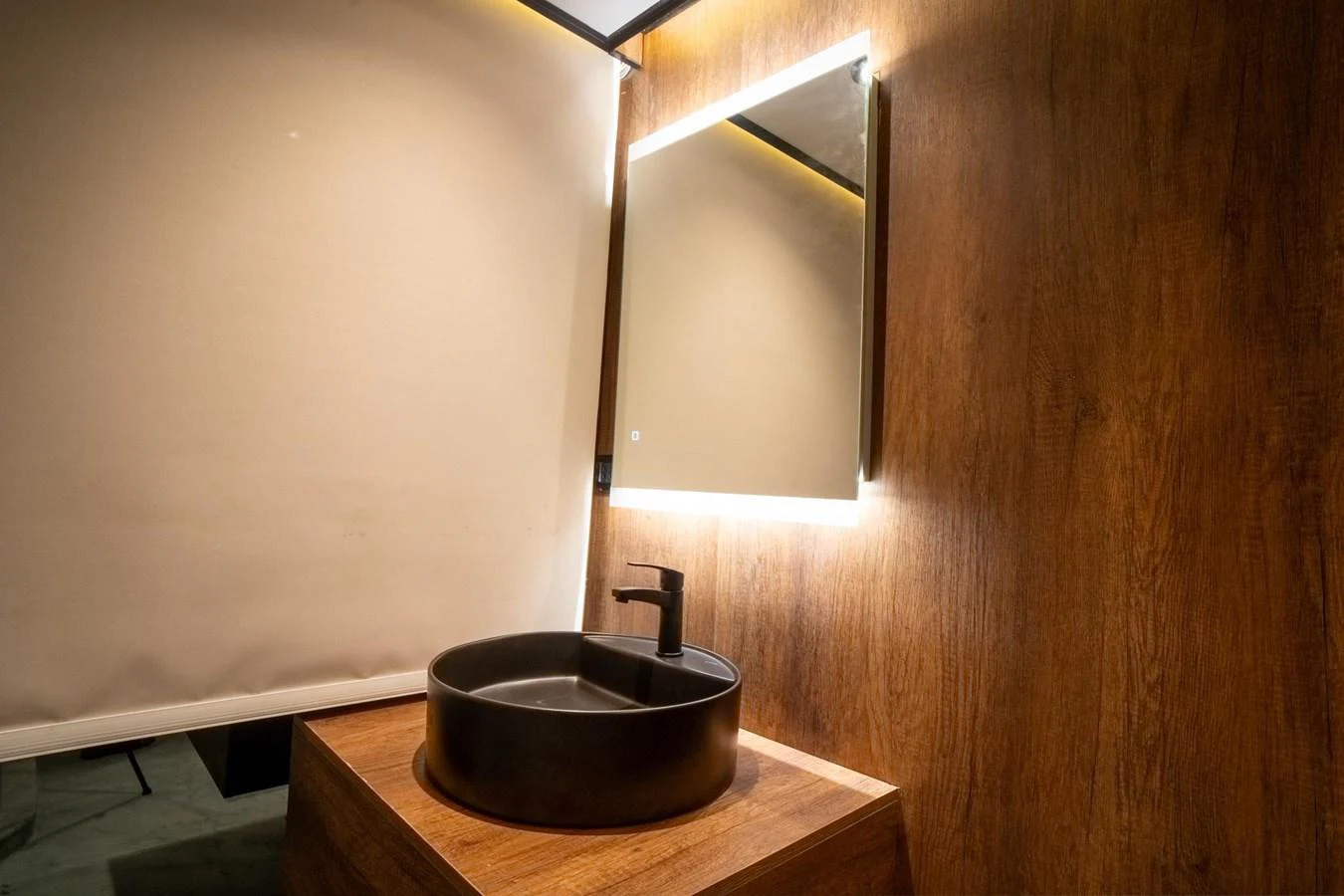 A modern bathroom with a sleek round sink and illuminated mirror. aboard JASMINE Yacht for Sale