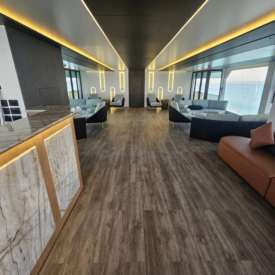 The spacious salon features modern furnishings and expansive windows offering stunning sea views. aboard JASMINE Yacht for Sale