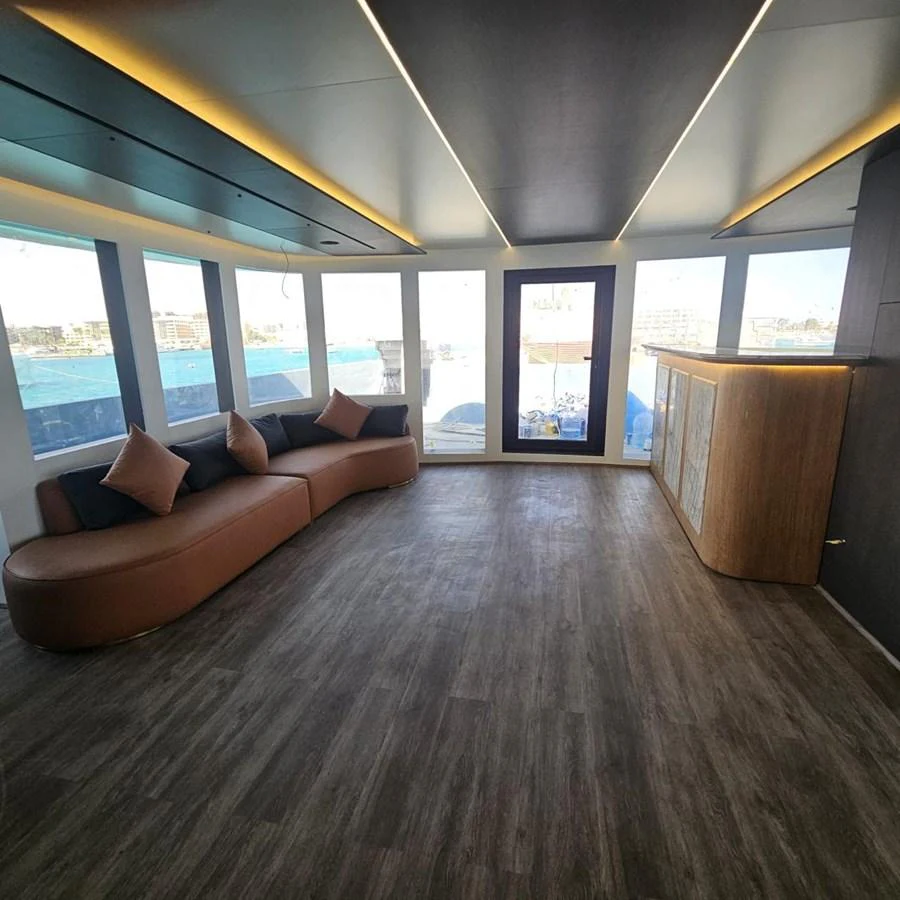 A spacious and modern interior lounge area with large windows offering panoramic views. aboard JASMINE Yacht for Sale