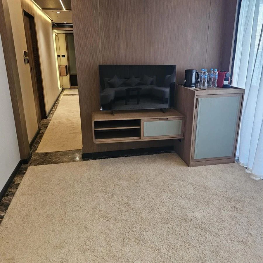 A cozy interior space featuring a television, a cabinet, and a hallway leading to other areas. aboard JASMINE Yacht for Sale