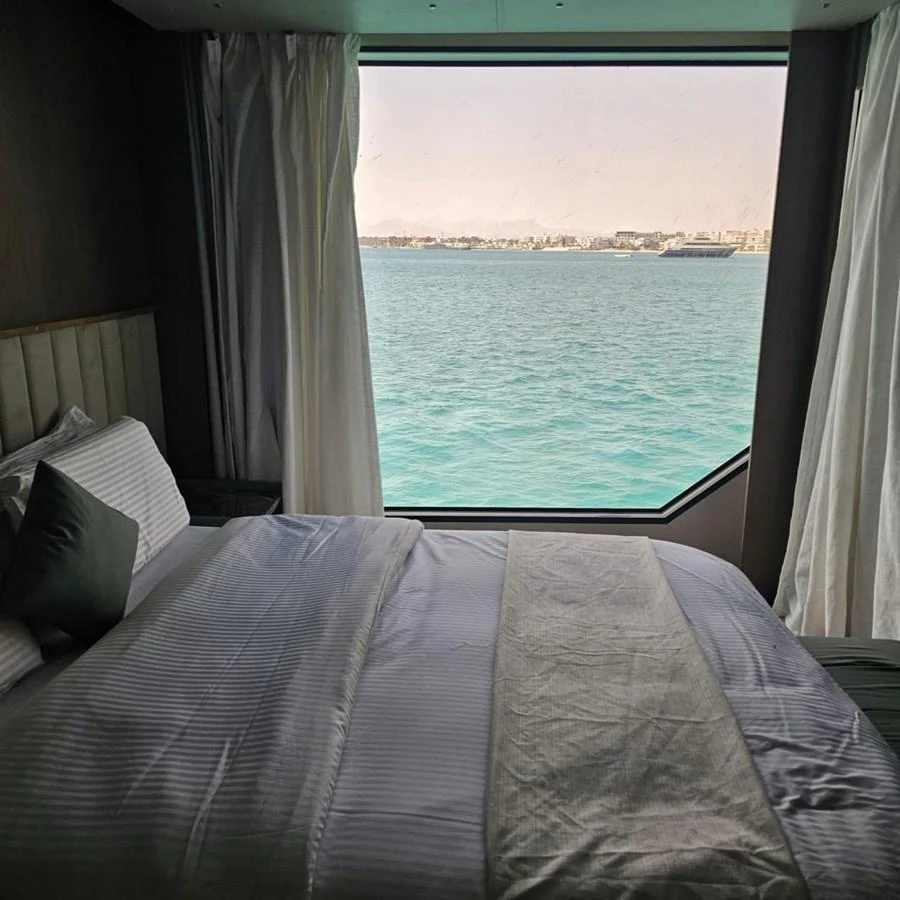 A serene stateroom with a large window offering a stunning view of the sea. aboard JASMINE Yacht for Sale