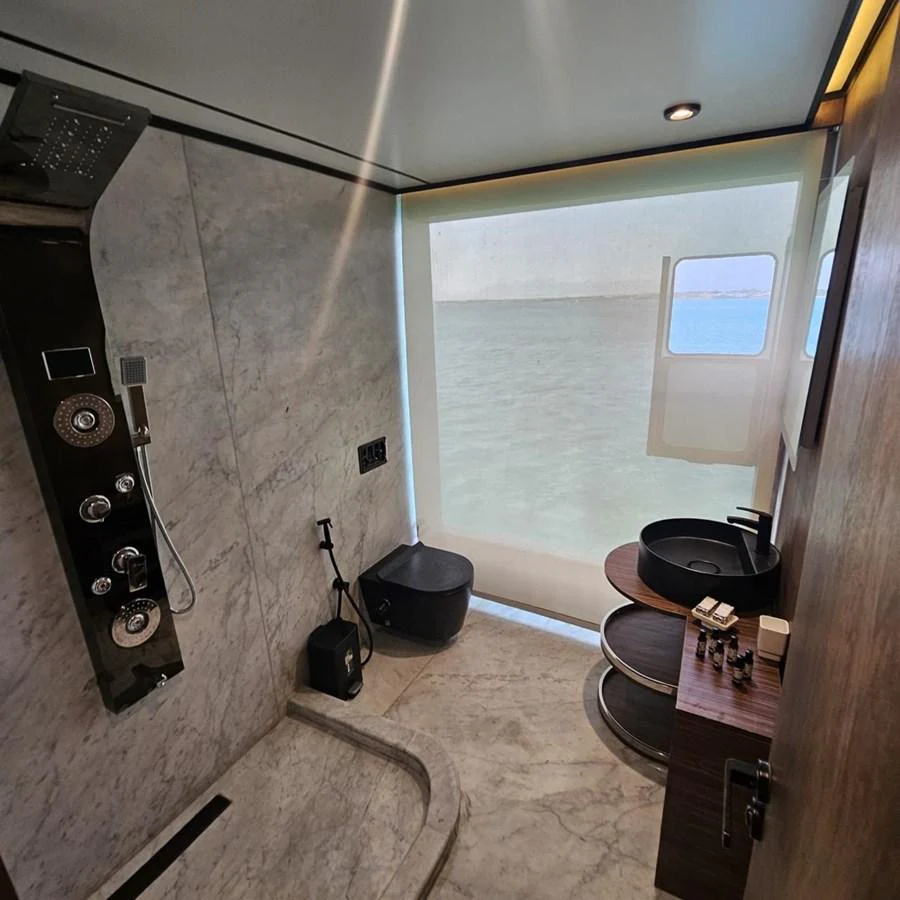 The yacht's bathroom features a sleek design with modern fixtures and a view of the sea through the window. aboard JASMINE Yacht for Sale