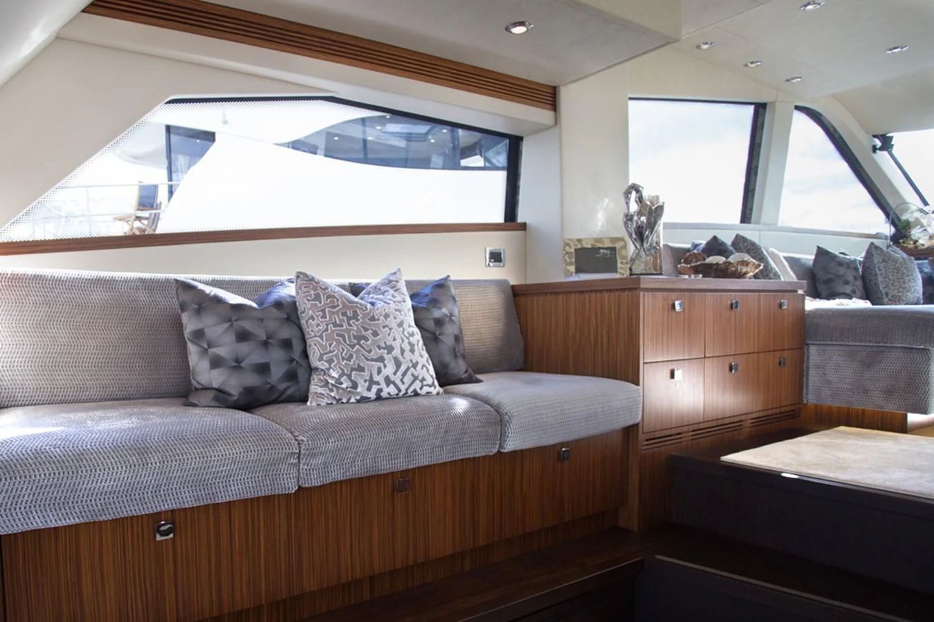 The yacht's interior features a cozy seating area with plush cushions and elegant wooden cabinetry. aboard MAZARIN 72 FLYBRIDGE Yacht for Sale