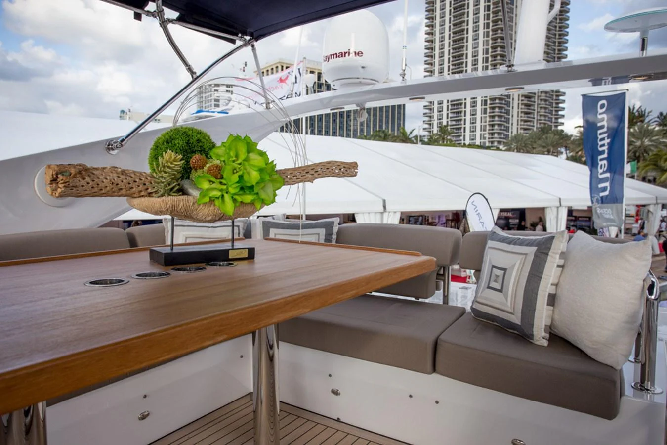 The flybridge features a stylish seating area with a wooden table and decorative centerpiece, perfect for outdoor relaxation. aboard MAZARIN 72 FLYBRIDGE Yacht for Sale