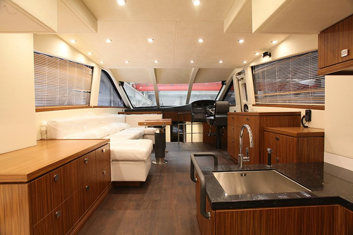The yacht's salon features elegant wood cabinetry, a comfortable seating area, and modern fixtures. aboard MAZARIN 72 FLYBRIDGE Yacht for Sale
