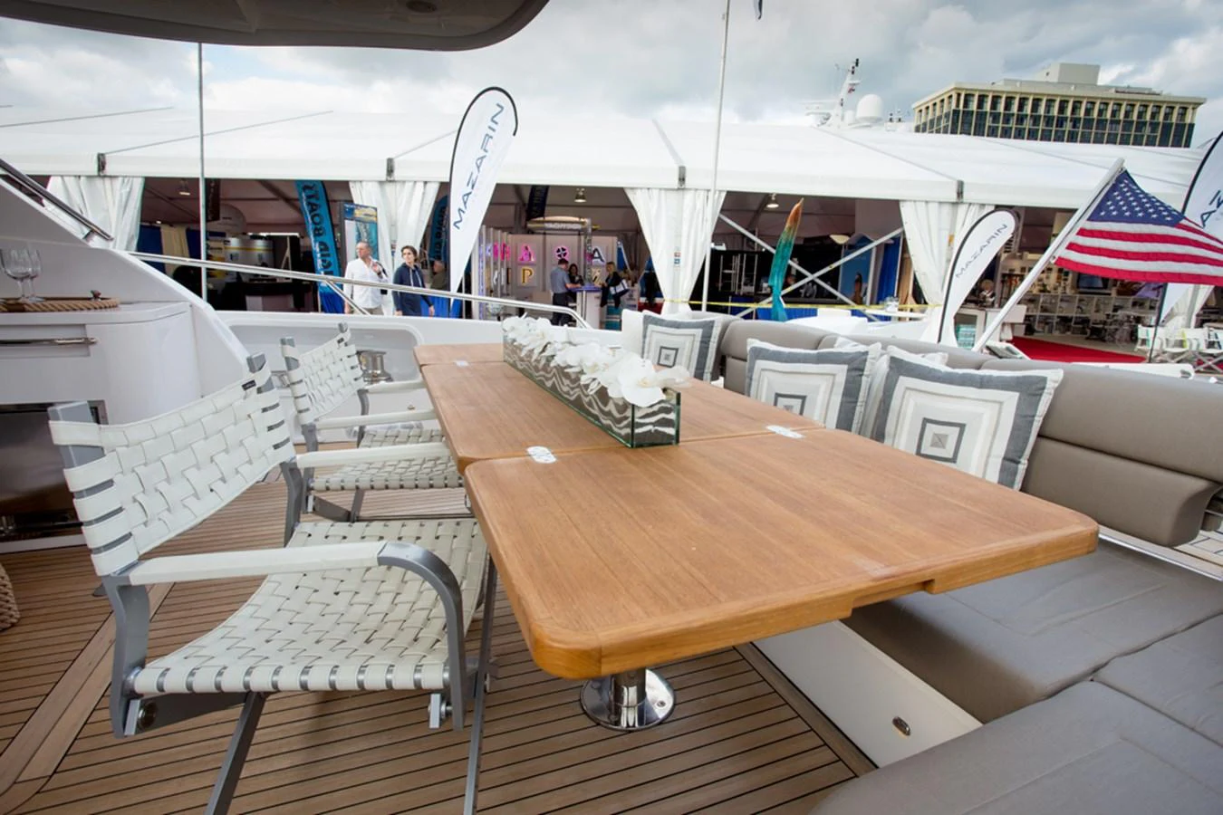 The aft deck features a stylish dining area with a wooden table and comfortable seating. aboard MAZARIN 72 FLYBRIDGE Yacht for Sale