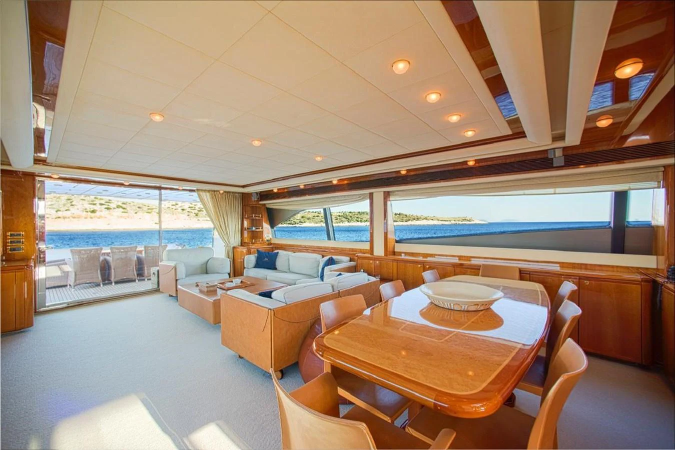 The yacht's salon offers a spacious and elegant setting with comfortable seating and a dining area, complemented by large windows providing stunning views. aboard FERRETTI 881 Yacht for Sale