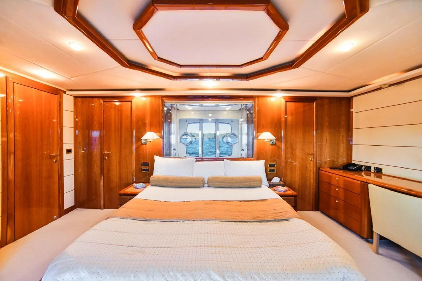 The master stateroom features a luxurious bed, warm wood finishes, and elegant lighting. aboard FERRETTI 881 Yacht for Sale