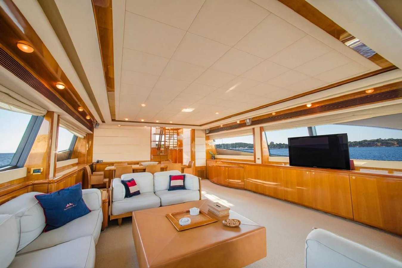 The yacht's salon features luxurious seating, ample natural light, and a flat-screen TV for entertainment. aboard FERRETTI 881 Yacht for Sale