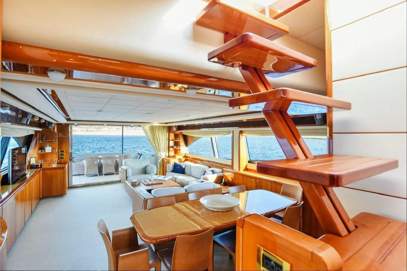 The salon features luxurious seating with panoramic windows offering stunning ocean views. aboard FERRETTI 881 Yacht for Sale