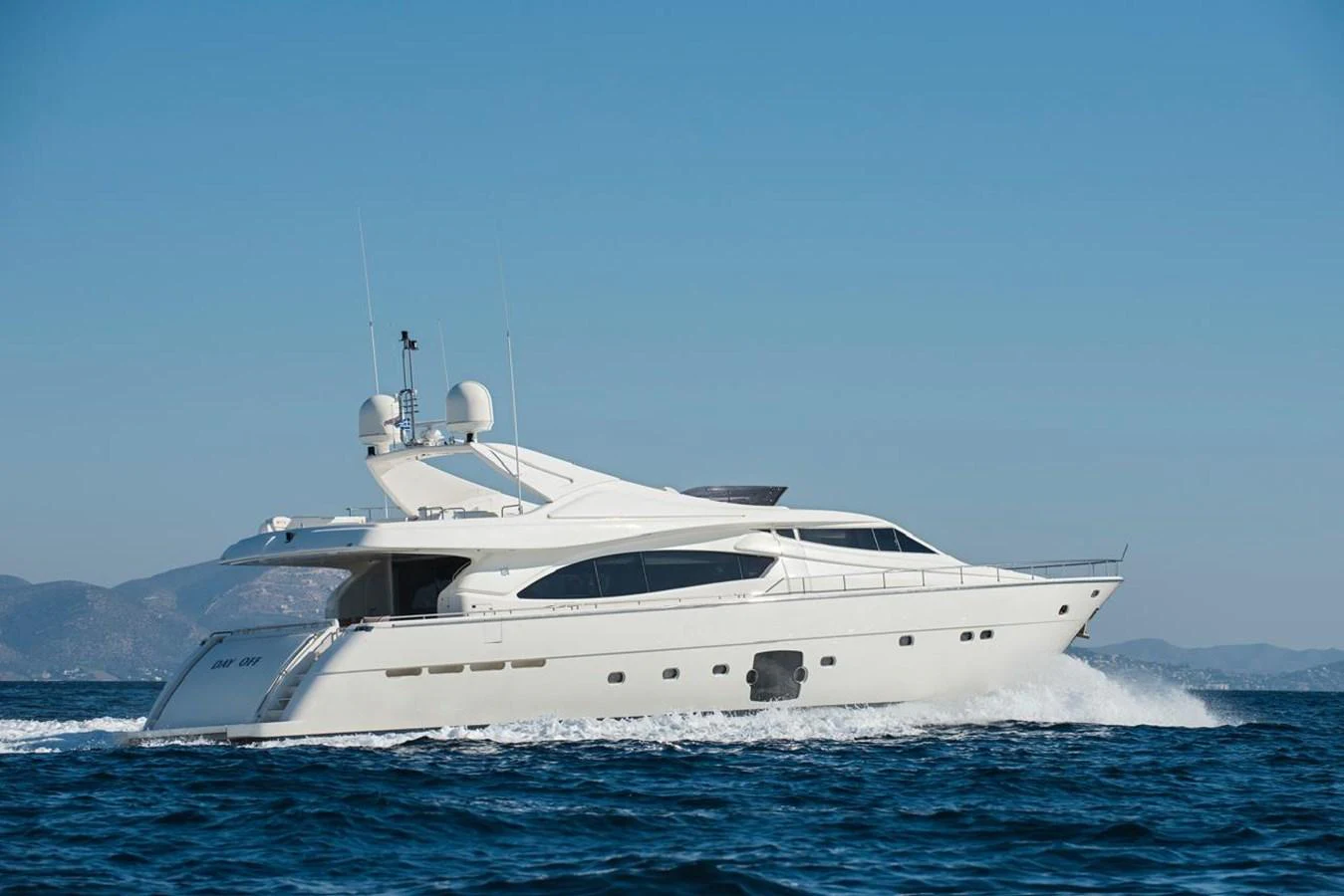 A sleek white yacht cruises swiftly across the open sea under a clear blue sky. aboard FERRETTI 881 Yacht for Sale