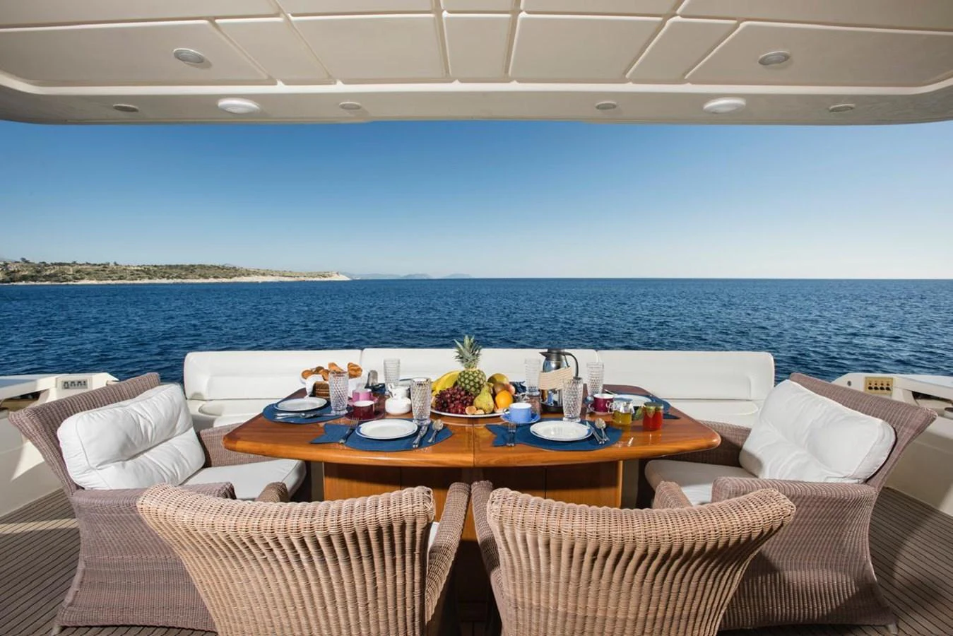 The aft deck features a beautifully set dining table with a stunning ocean view. aboard FERRETTI 881 Yacht for Sale