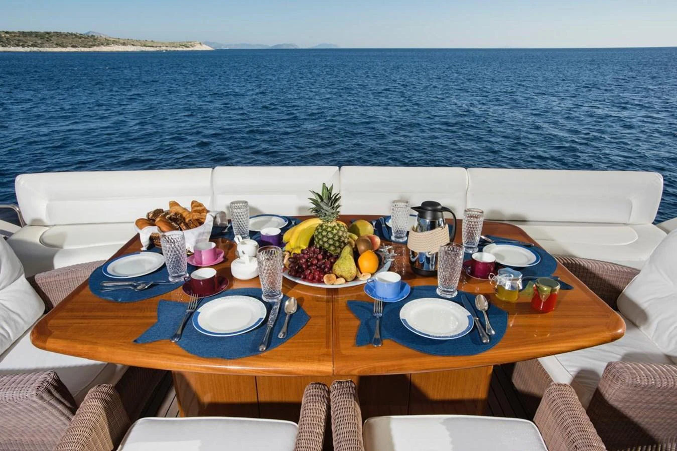 An inviting aft deck dining area set for a meal with a stunning ocean backdrop. aboard FERRETTI 881 Yacht for Sale