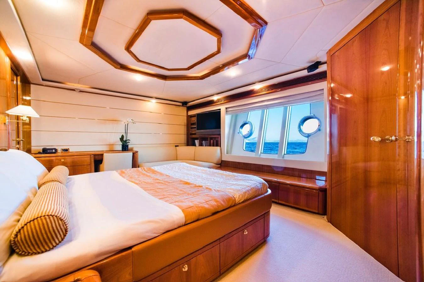 The master stateroom features a luxurious bed, elegant wood finishes, and ample natural light from the large windows. aboard FERRETTI 881 Yacht for Sale
