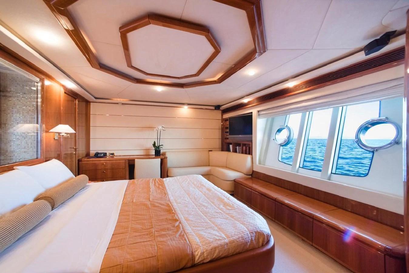 The master stateroom features a spacious bed, elegant wood finishes, and large windows with ocean views. aboard FERRETTI 881 Yacht for Sale