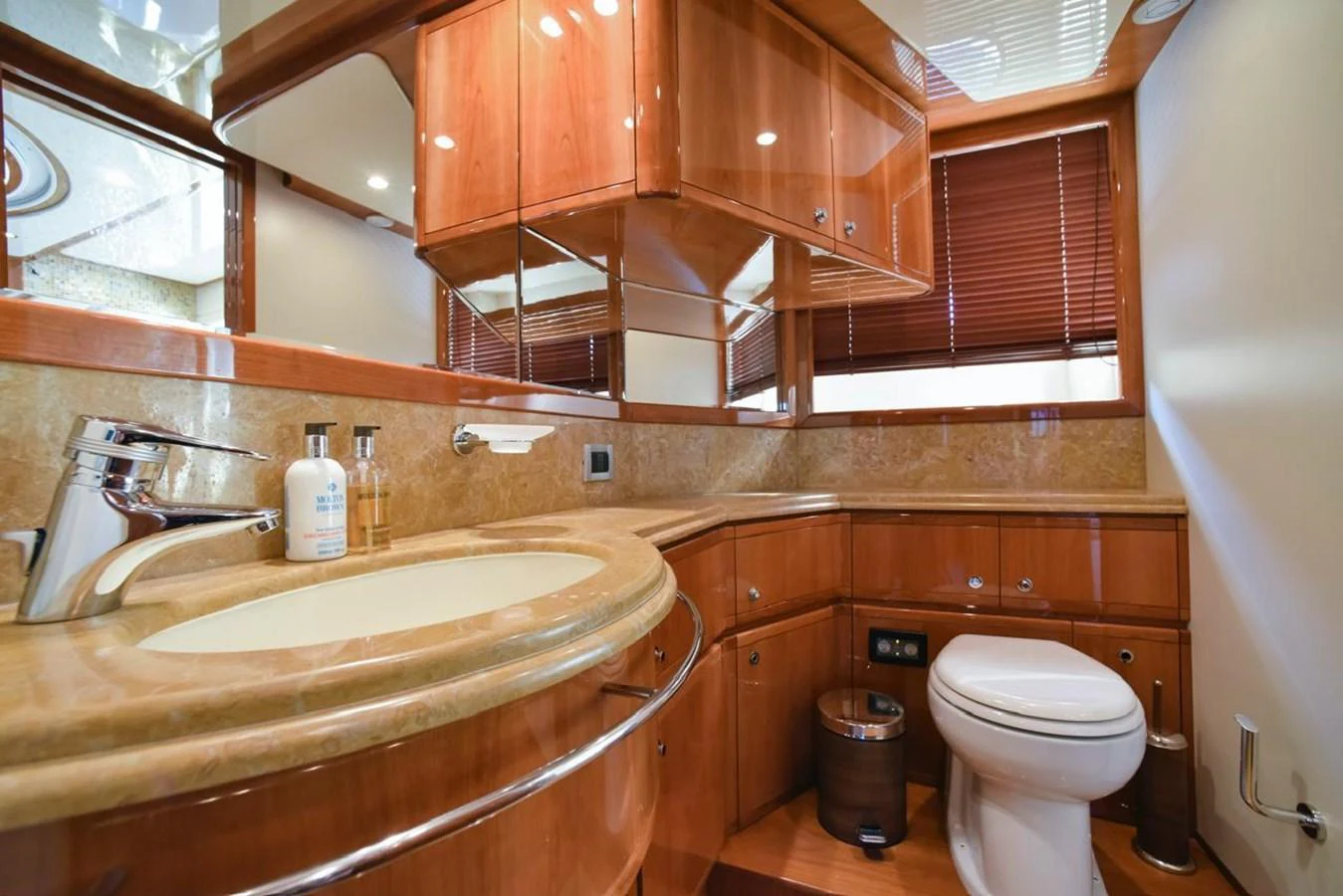 The yacht's bathroom features luxurious wood cabinetry and elegant fixtures. aboard FERRETTI 881 Yacht for Sale