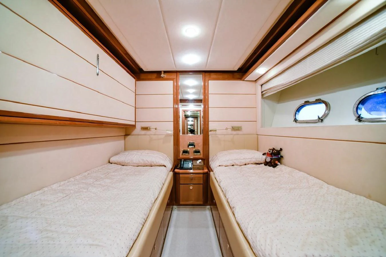 The twin stateroom offers a cozy and inviting space with two single beds and elegant wood accents. aboard FERRETTI 881 Yacht for Sale