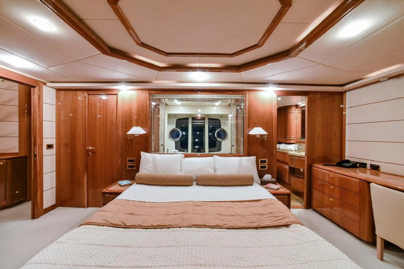 The master stateroom features elegant wood paneling and a spacious, luxurious bed. aboard FERRETTI 881 Yacht for Sale