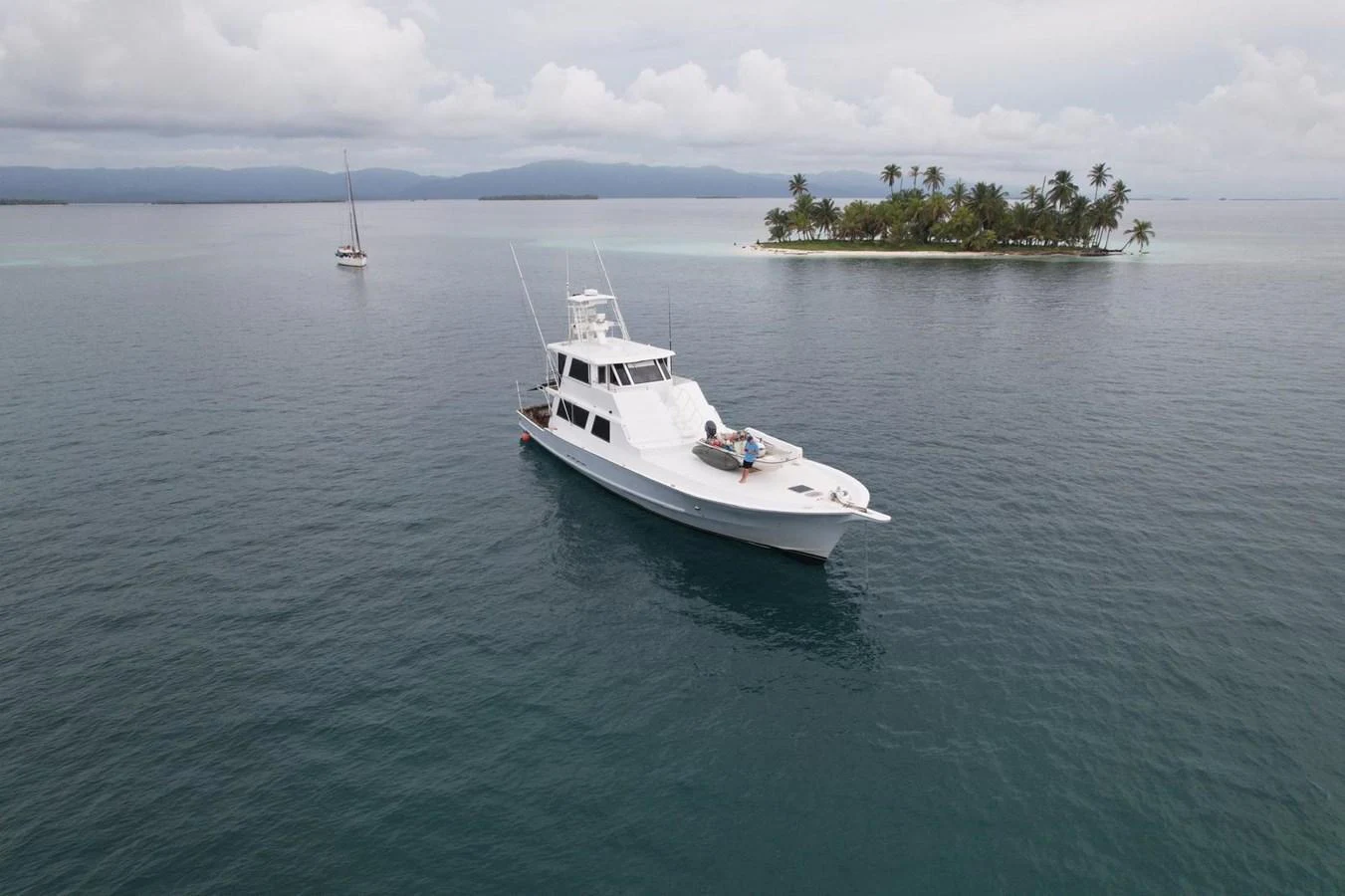 A sleek yacht cruises peacefully near a tropical island, offering a serene escape on the water. aboard ADDISYN ANN Yacht for Sale