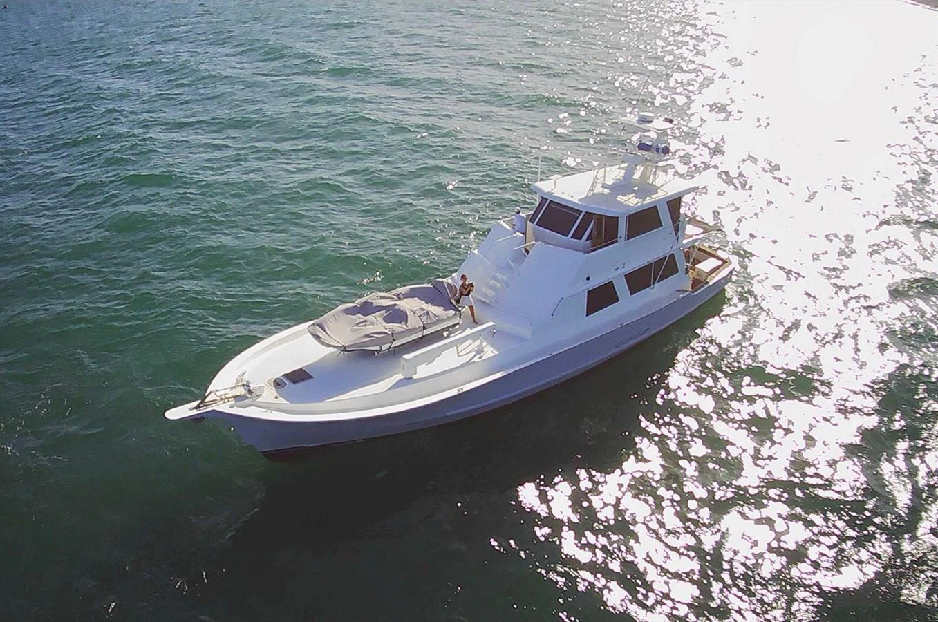 A sleek yacht cruises on calm waters under bright sunlight. aboard ADDISYN ANN Yacht for Sale