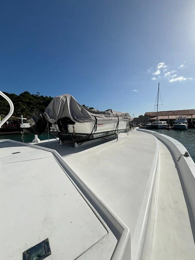 The yacht's exterior deck features a covered tender, docked in a serene marina. aboard ADDISYN ANN Yacht for Sale