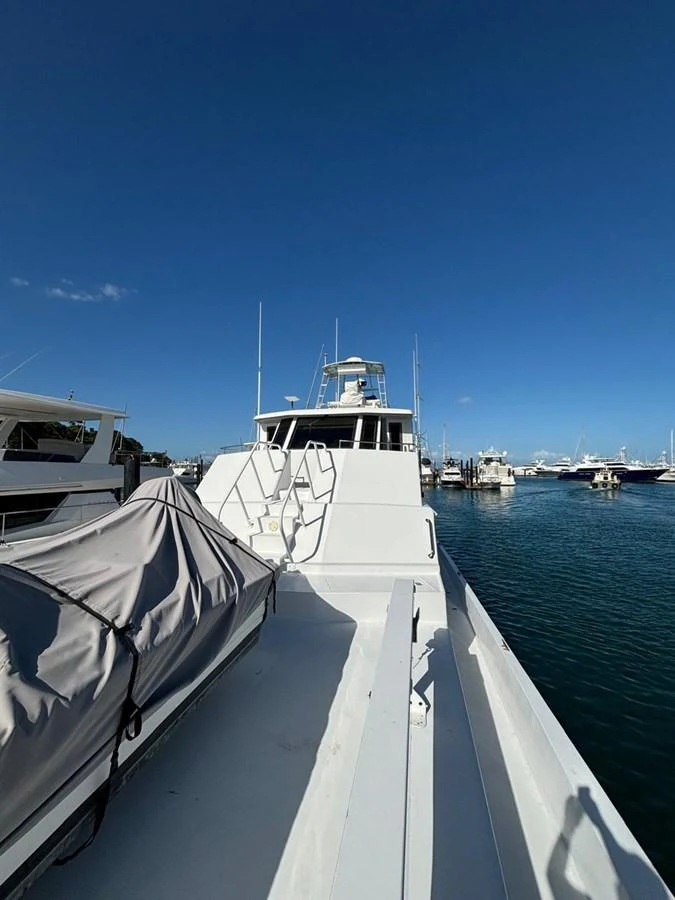 A sleek yacht docked at a marina under a clear blue sky. aboard ADDISYN ANN Yacht for Sale