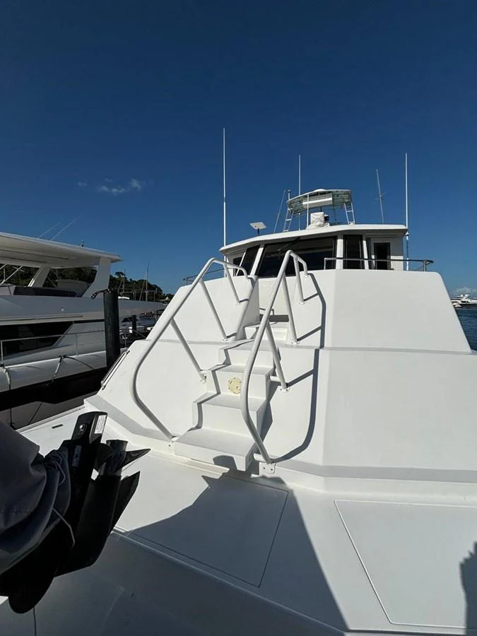 The yacht's exterior features a sleek, modern design with a prominent staircase leading to the upper deck. aboard ADDISYN ANN Yacht for Sale