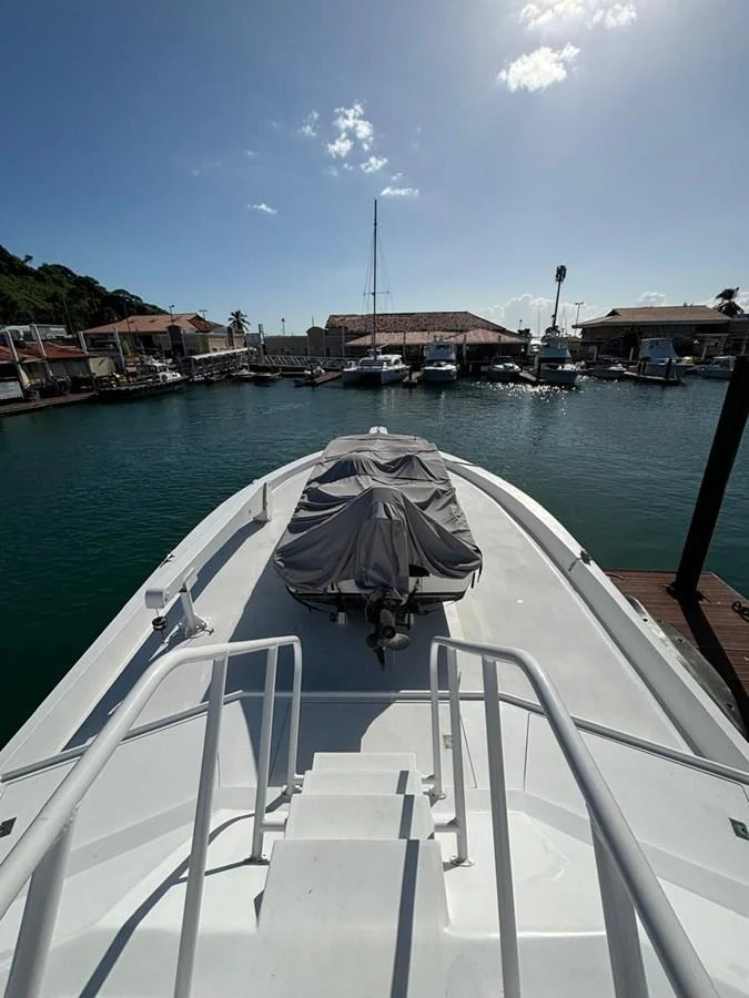 The yacht is docked at a marina, with a covered tender on the bow. aboard ADDISYN ANN Yacht for Sale