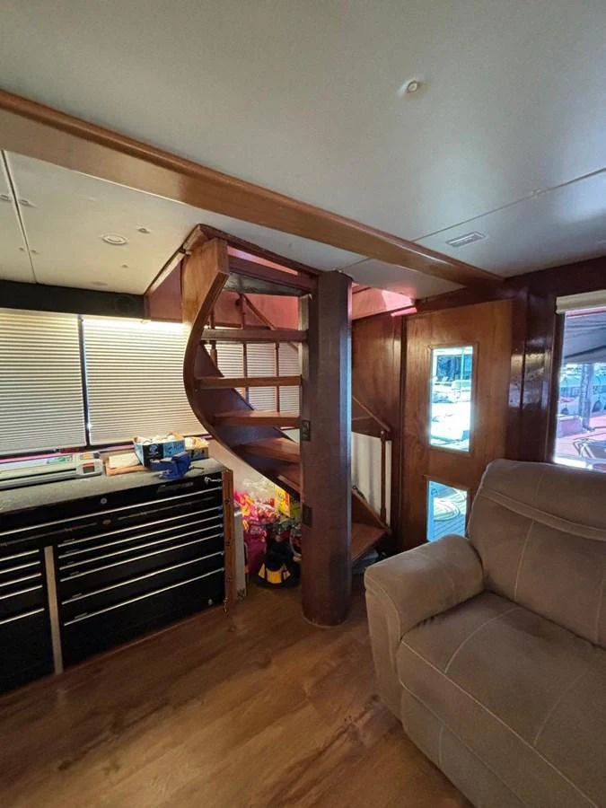 A cozy interior space featuring a spiral staircase and comfortable seating. aboard ADDISYN ANN Yacht for Sale